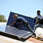 Placement des premiers panneaux solaires sur le toit des classes.